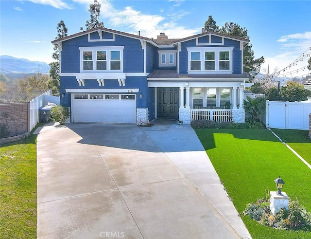 view of front of house featuring driveway, a front yard, fence, and a mountain view