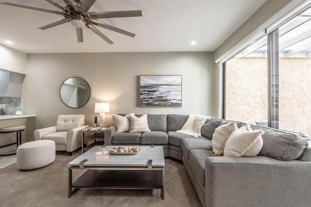 carpeted living room with ceiling fan