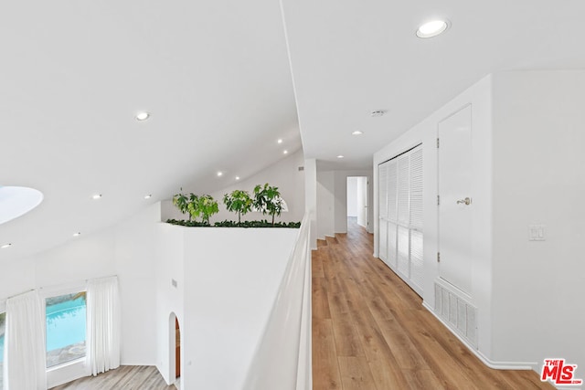 hallway featuring lofted ceiling and light wood-type flooring