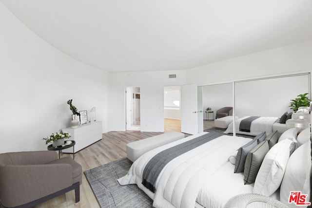 bedroom with a closet and light hardwood / wood-style flooring