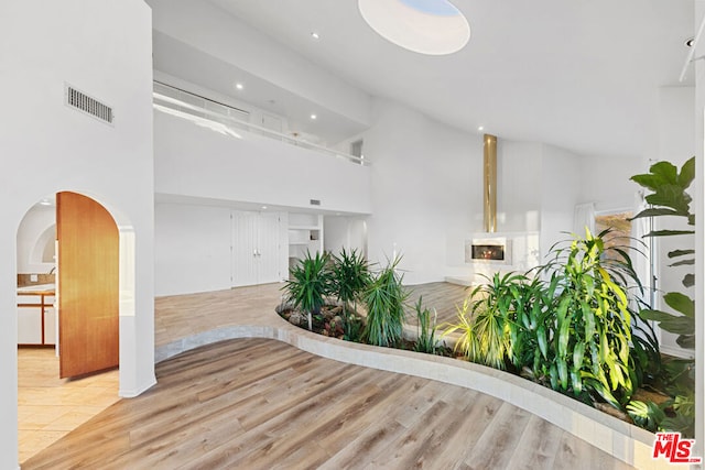 interior space featuring light hardwood / wood-style flooring and high vaulted ceiling