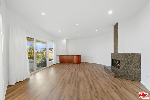 unfurnished living room with hardwood / wood-style floors and a fireplace