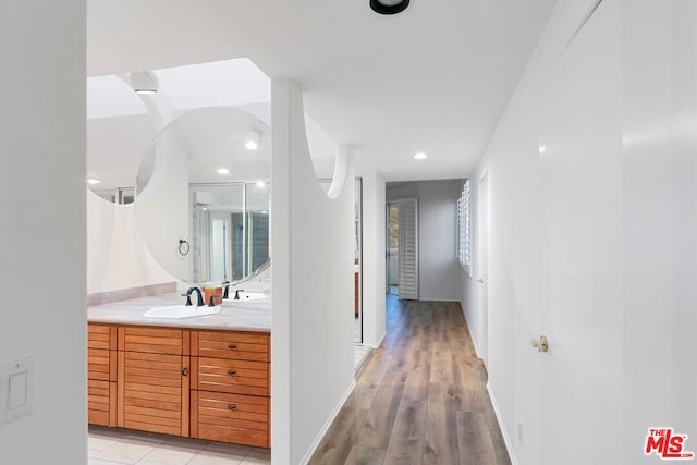 hall with sink and light hardwood / wood-style flooring