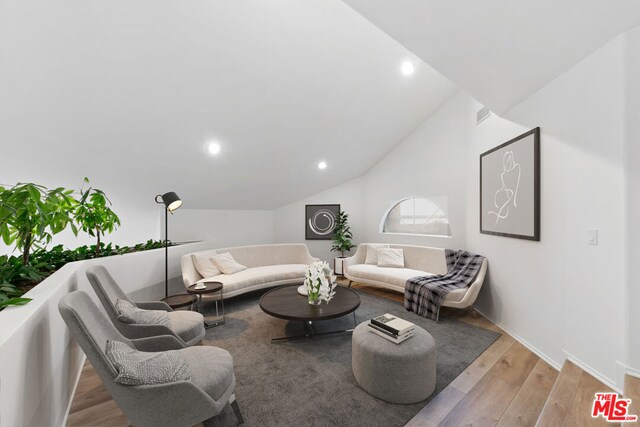 living room featuring vaulted ceiling and light hardwood / wood-style flooring