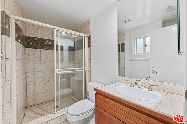 bathroom with walk in shower, vanity, and toilet