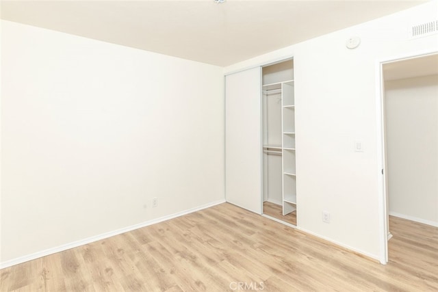 unfurnished bedroom with light hardwood / wood-style floors and a closet