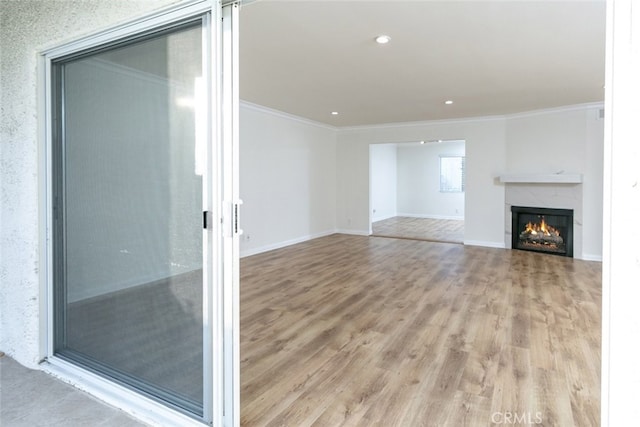 unfurnished living room with crown molding and light hardwood / wood-style flooring