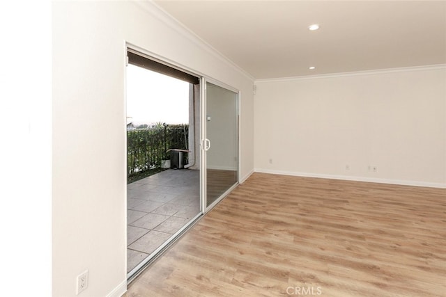 spare room featuring ornamental molding and light hardwood / wood-style flooring