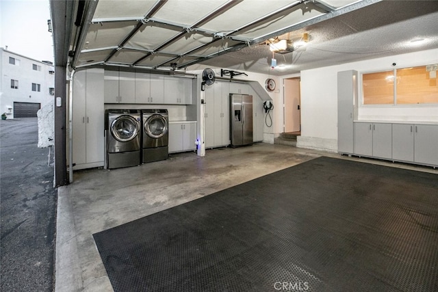 garage featuring a garage door opener, separate washer and dryer, and stainless steel fridge with ice dispenser