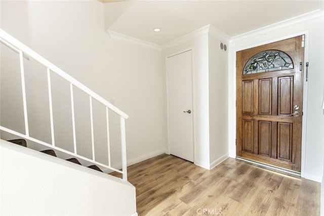 foyer entrance featuring crown molding and light hardwood / wood-style floors