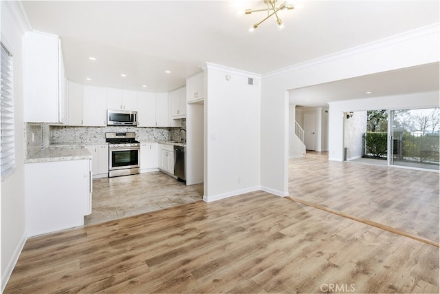 kitchen featuring sink, crown molding, appliances with stainless steel finishes, decorative backsplash, and white cabinets