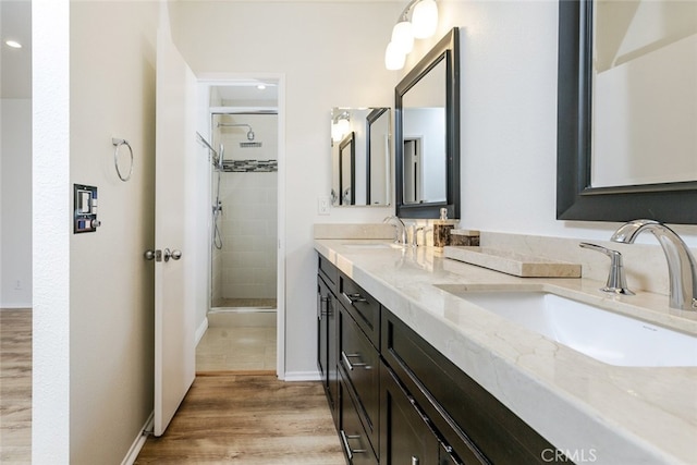 bathroom with hardwood / wood-style flooring, vanity, and walk in shower