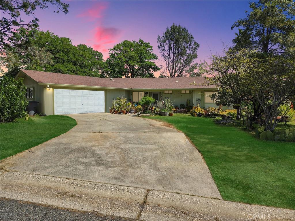 ranch-style house with a garage and a lawn