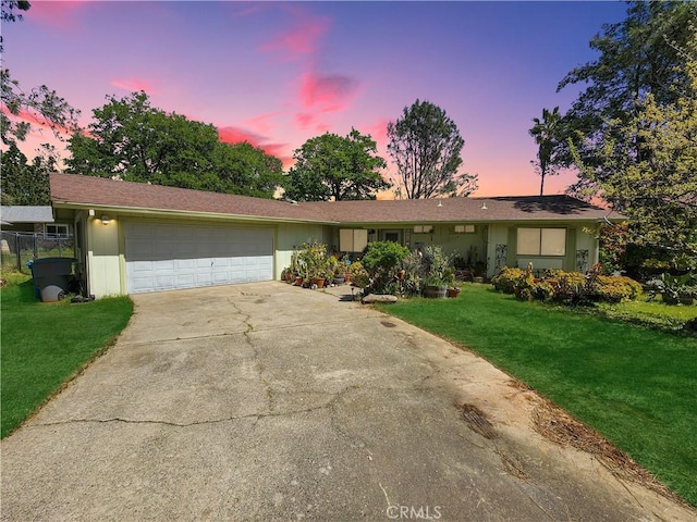 ranch-style house with a garage and a yard