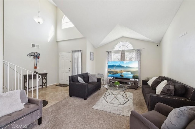 carpeted living room with high vaulted ceiling