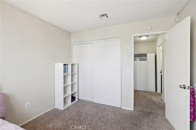 unfurnished bedroom with a closet, a textured ceiling, and carpet