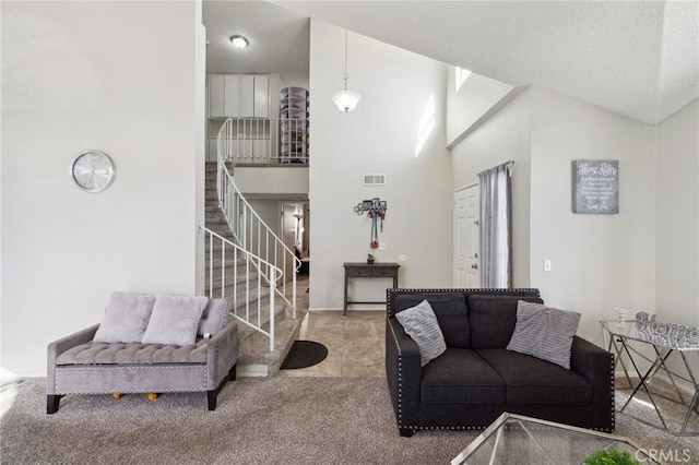 carpeted living room featuring a high ceiling and a textured ceiling