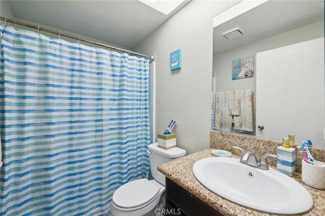 bathroom featuring vanity, curtained shower, and toilet