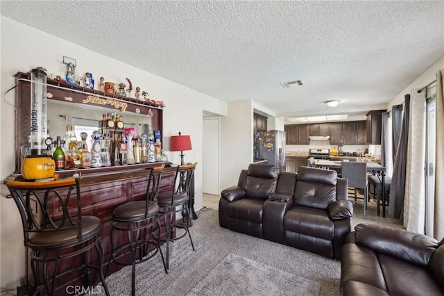 living room with indoor bar, carpet floors, and a textured ceiling