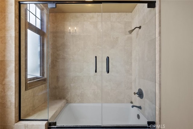 bathroom featuring plenty of natural light and combined bath / shower with glass door
