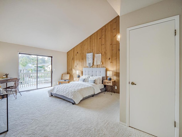 bedroom featuring access to outside, wooden walls, vaulted ceiling, and carpet flooring