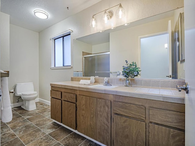 bathroom featuring vanity, toilet, and walk in shower