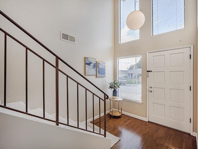 foyer featuring a high ceiling and dark hardwood / wood-style flooring