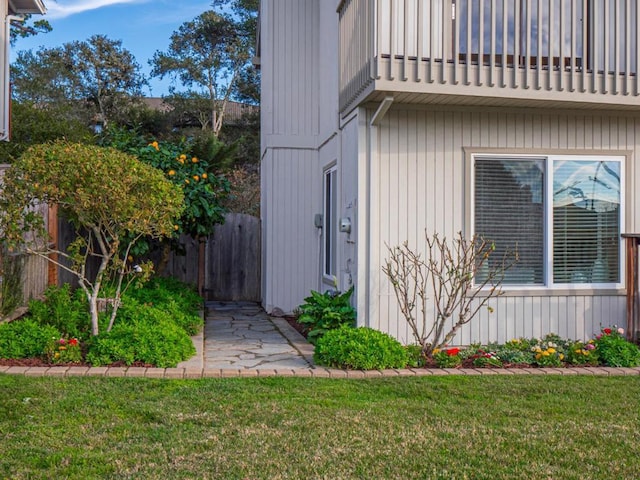 view of property exterior with a yard and a balcony