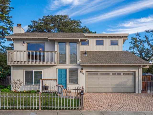 view of front of home with a garage, a front lawn, and a balcony