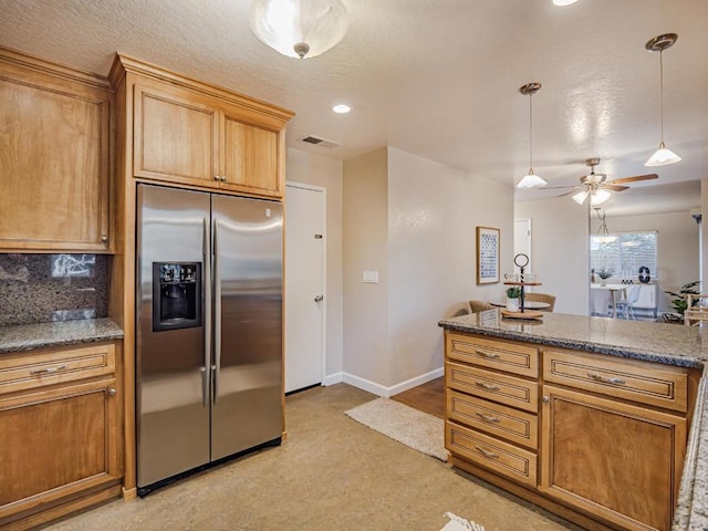 kitchen featuring decorative light fixtures, tasteful backsplash, stainless steel fridge, ceiling fan, and a textured ceiling