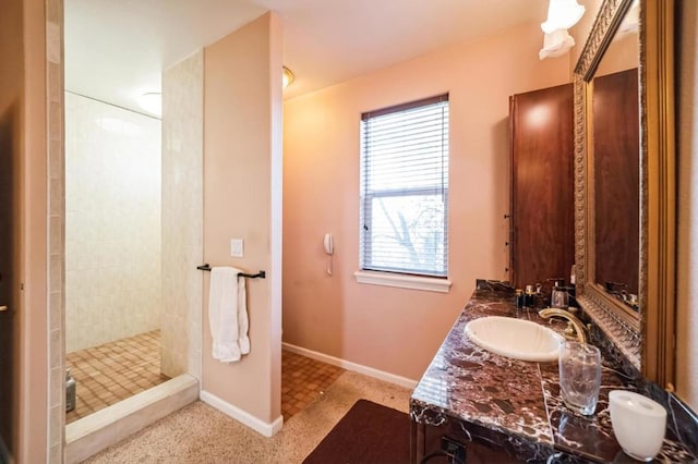 bathroom with vanity and a tile shower