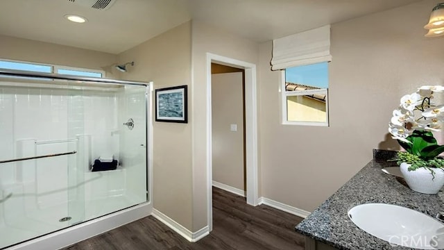 bathroom featuring a shower with door, hardwood / wood-style flooring, and a wealth of natural light