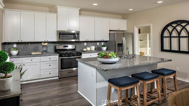 kitchen featuring sink, a center island with sink, white cabinets, and appliances with stainless steel finishes