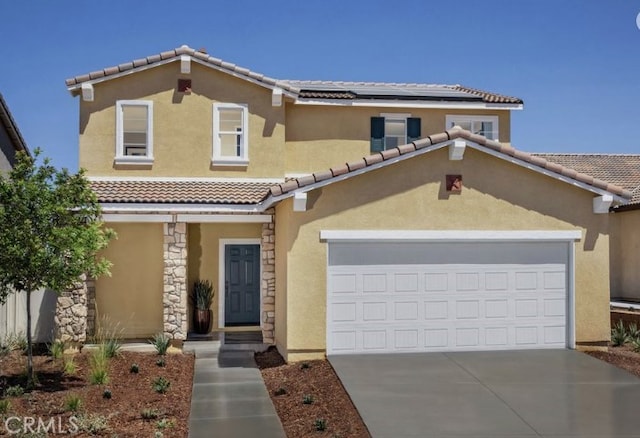 mediterranean / spanish-style home with a garage and solar panels