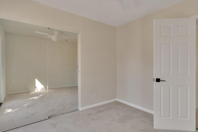 unfurnished bedroom featuring light carpet, a closet, and ceiling fan