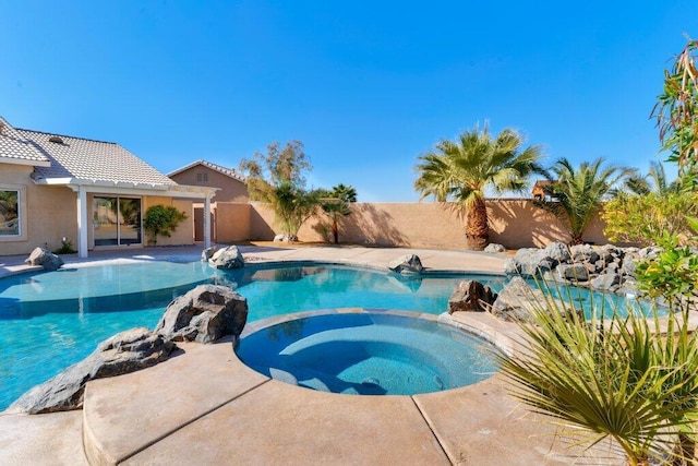 view of swimming pool with an in ground hot tub