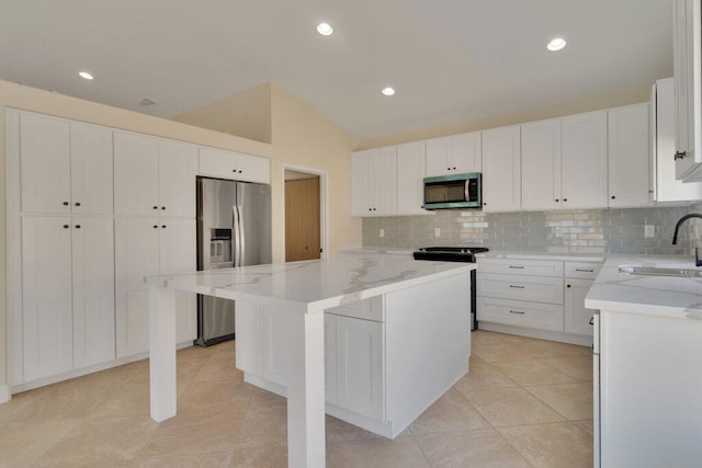 kitchen featuring stainless steel appliances, a center island, sink, and white cabinets