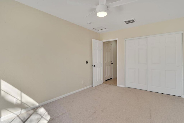 unfurnished bedroom with light colored carpet, ceiling fan, and a closet