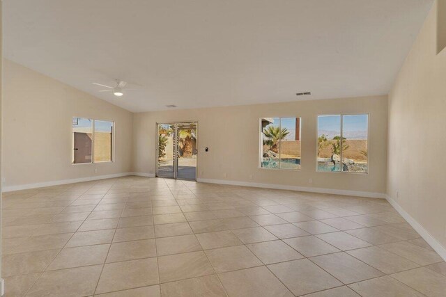 empty room featuring light tile patterned floors, vaulted ceiling, and ceiling fan