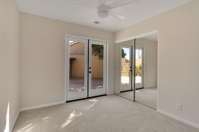 spare room with light colored carpet, french doors, and ceiling fan