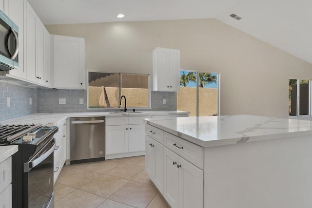 kitchen featuring white cabinetry, appliances with stainless steel finishes, a center island, and sink