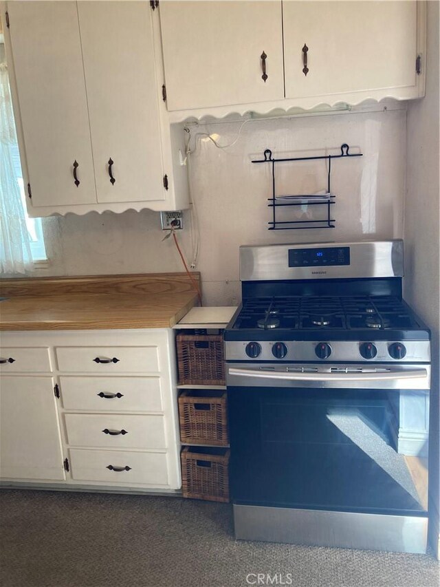 kitchen featuring stainless steel gas range and white cabinets