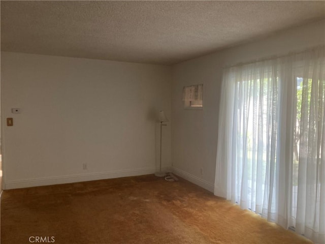 carpeted empty room featuring a textured ceiling