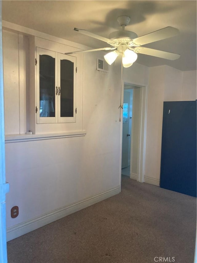 carpeted spare room with ceiling fan