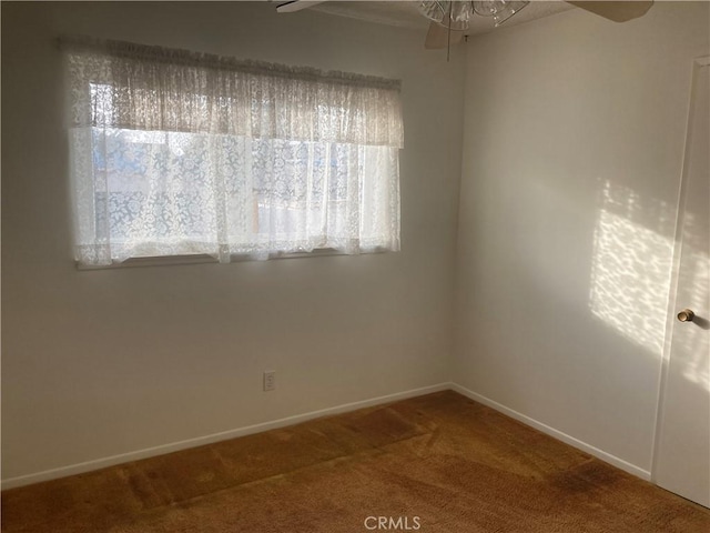 carpeted spare room featuring ceiling fan