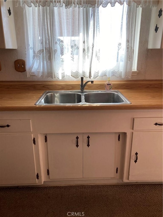 kitchen featuring white cabinetry and sink