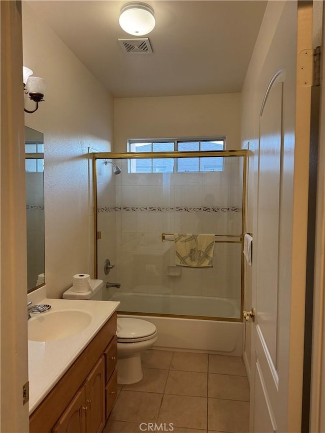 full bathroom with vanity, toilet, tile patterned floors, and bath / shower combo with glass door