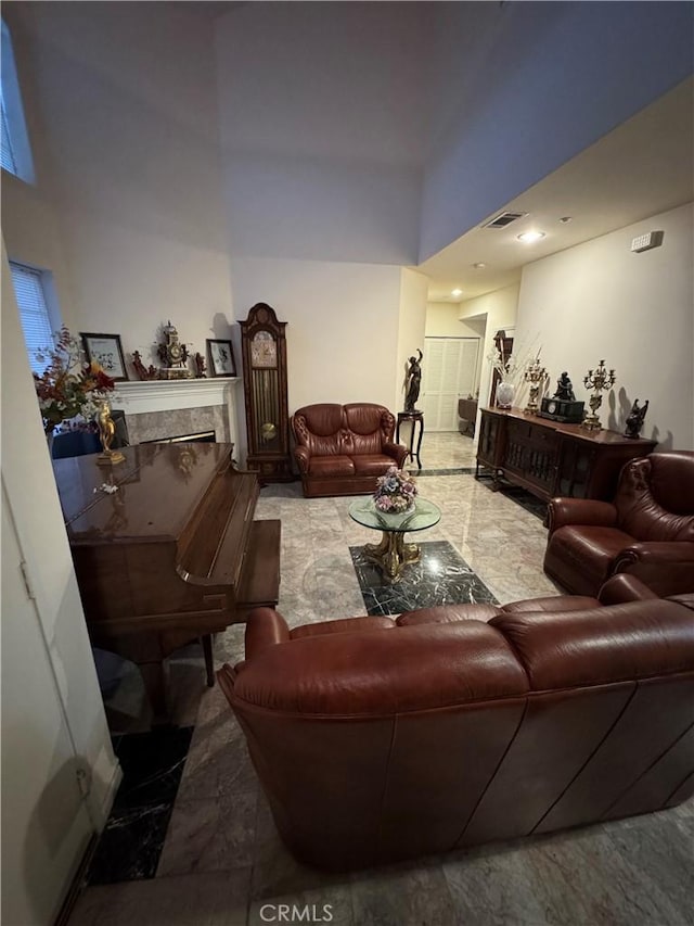 living room with a fireplace and a high ceiling