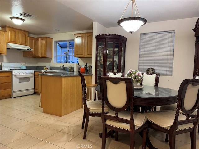 kitchen with hanging light fixtures, sink, white range with gas stovetop, and light tile patterned flooring