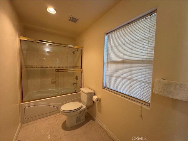 bathroom with shower / bath combination with glass door and toilet